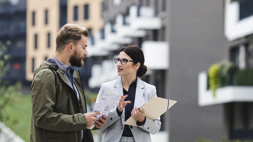 Property managers reviewing building plans outside a commercial property
