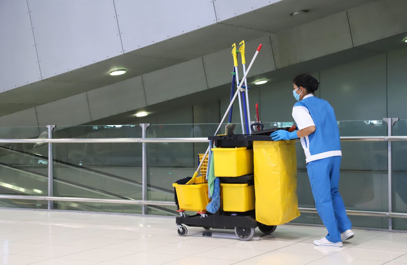 Janitorial staff with cleaning cart in a commercial building